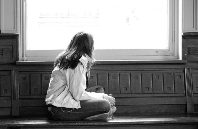 窓の外を見つめるアジア人女性