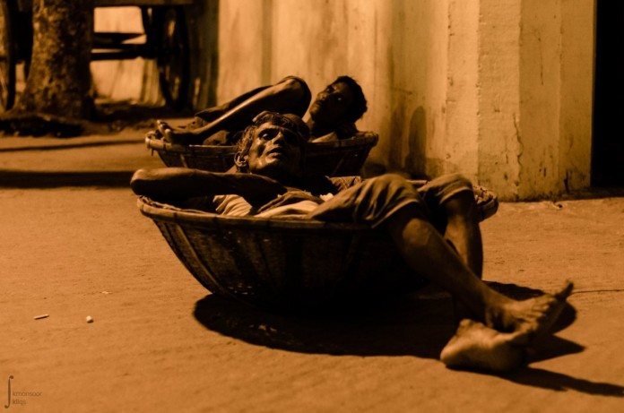 籠の中で眠るバングラディッシュの労働者